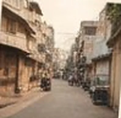 Residential lane lined with low-rise buildings and parked scooters